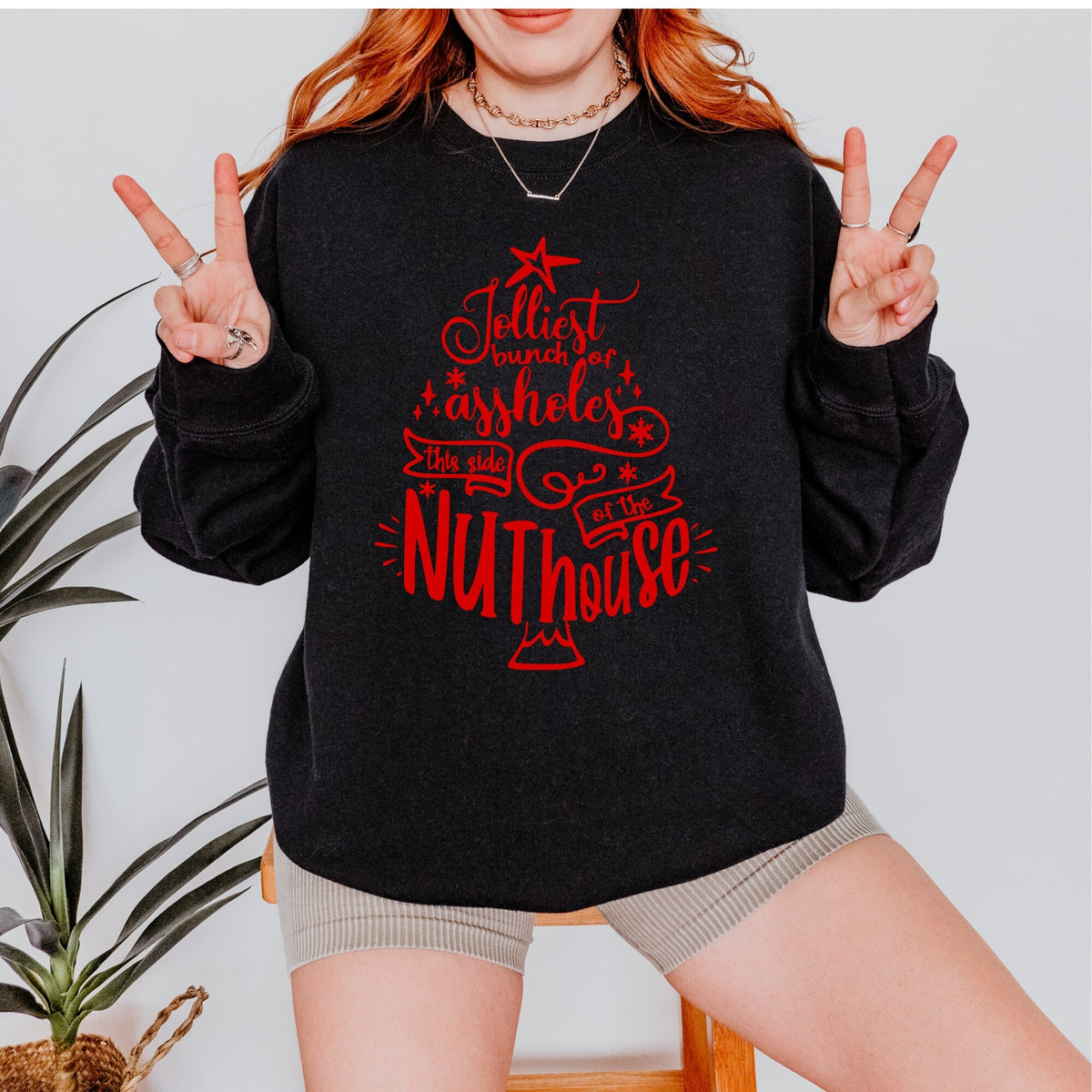 Christmas graphic sweatshirt featuring "Jolliest Bunch of A**holes in the Nuthouse"