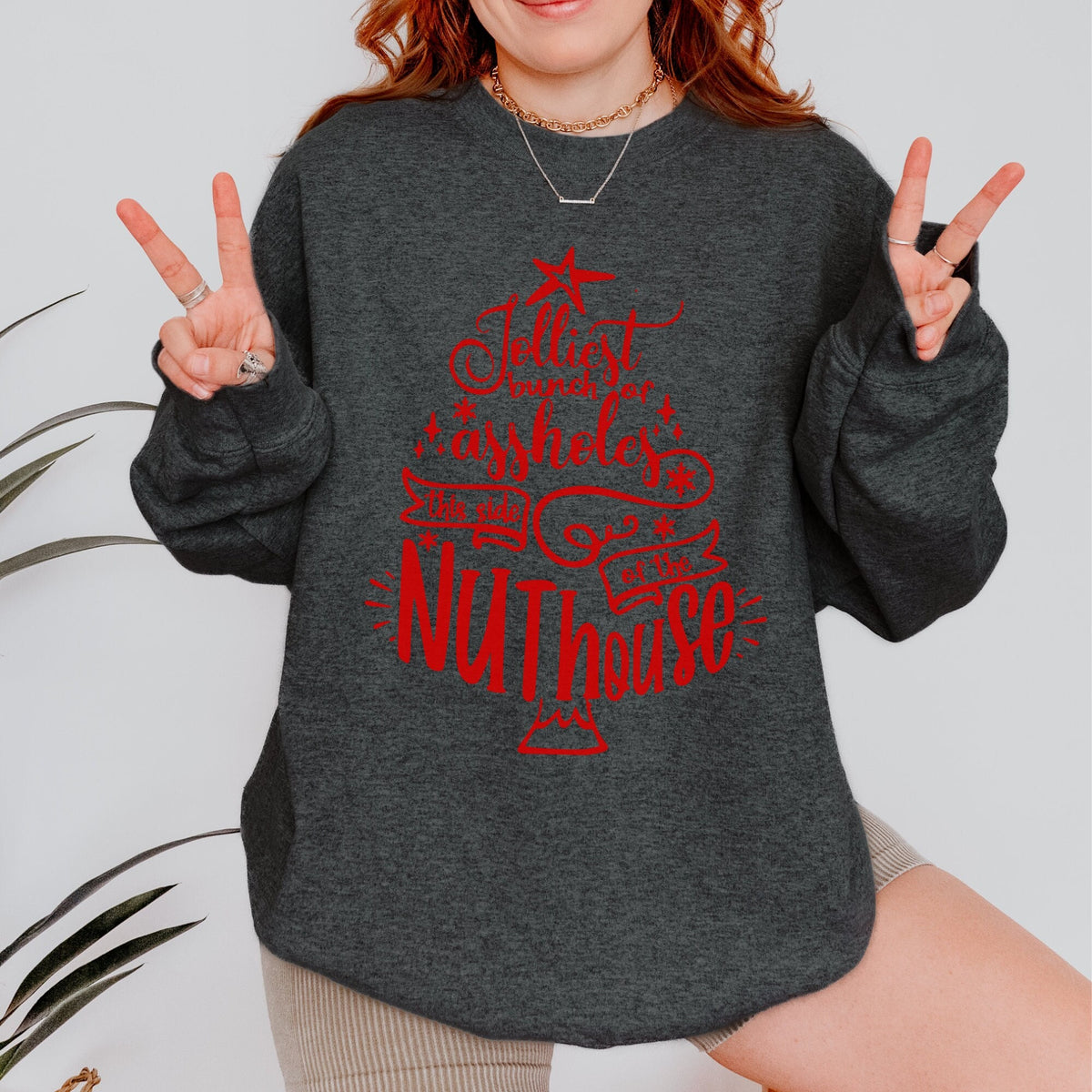 Christmas graphic sweatshirt featuring "Jolliest Bunch of A**holes in the Nuthouse"