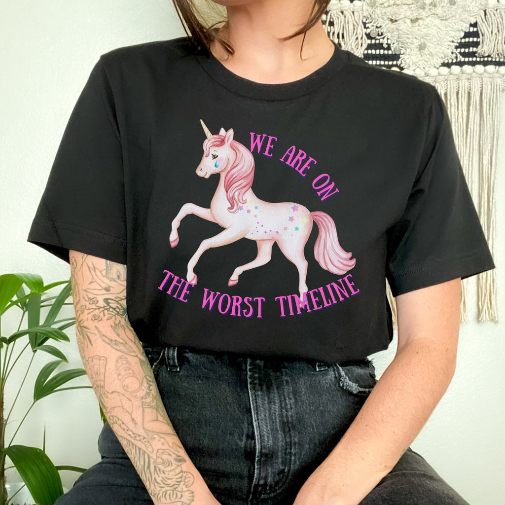 We Are on the Worst Timeline graphic shirt featuring Sad Unicorn Funny Graphic Tee in Black