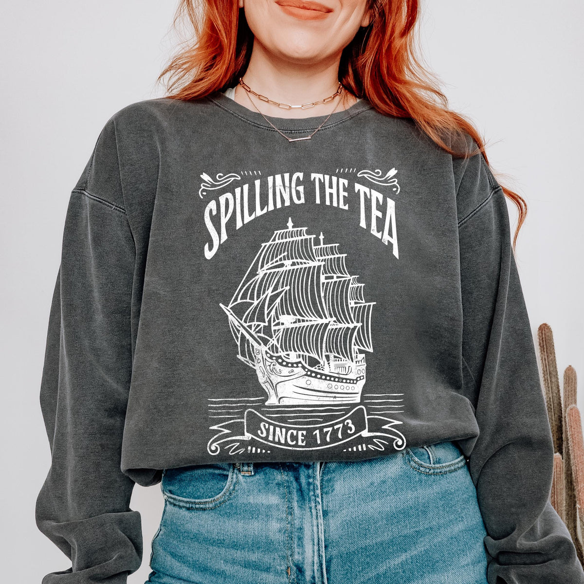 Spilling the Tea Since 1773 graphic sweatshirt featuring Boston Tea Party in Crimson