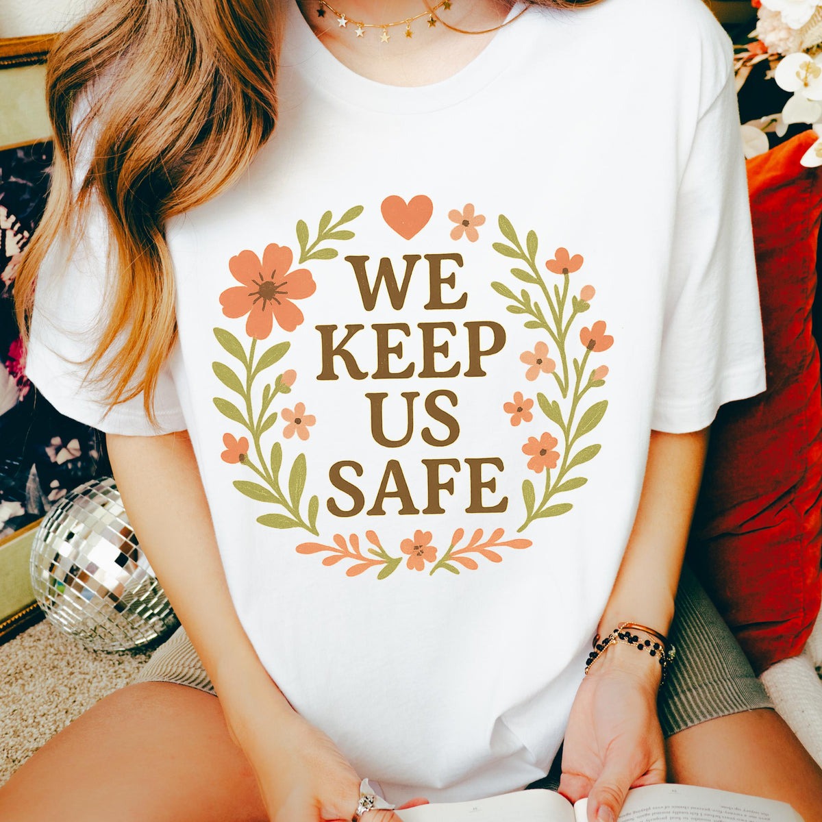 We Keep Us Safe graphic shirt featuring Mutual Aid & Community Care Floral