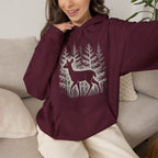 The Faithful Familiar maroon pullover hoodie featuring a white deer silhouette graphic in a snowy forest setting.