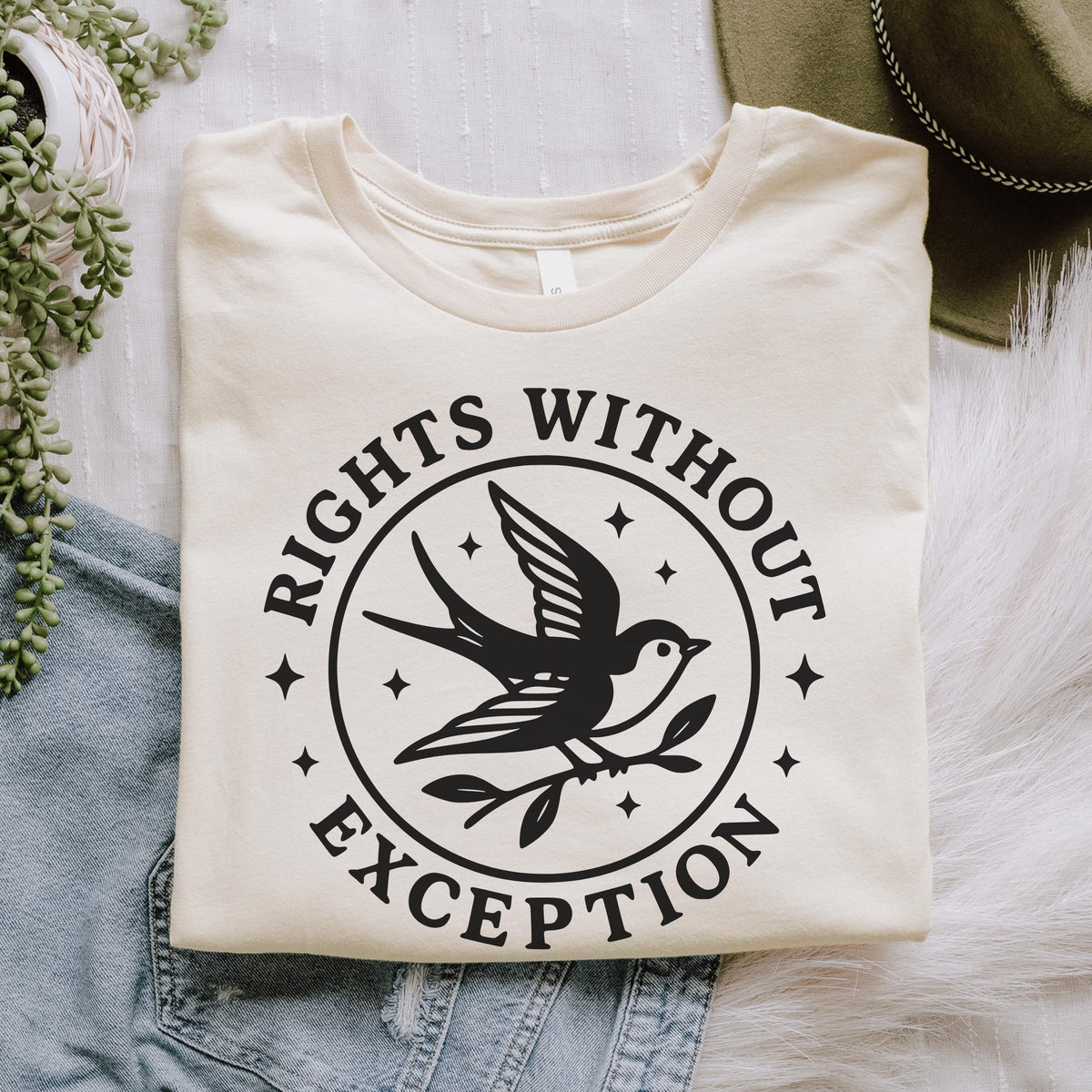 The Faithful Familiar cream graphic tee featuring a black swallow emblem with the text Rights Without Exception.