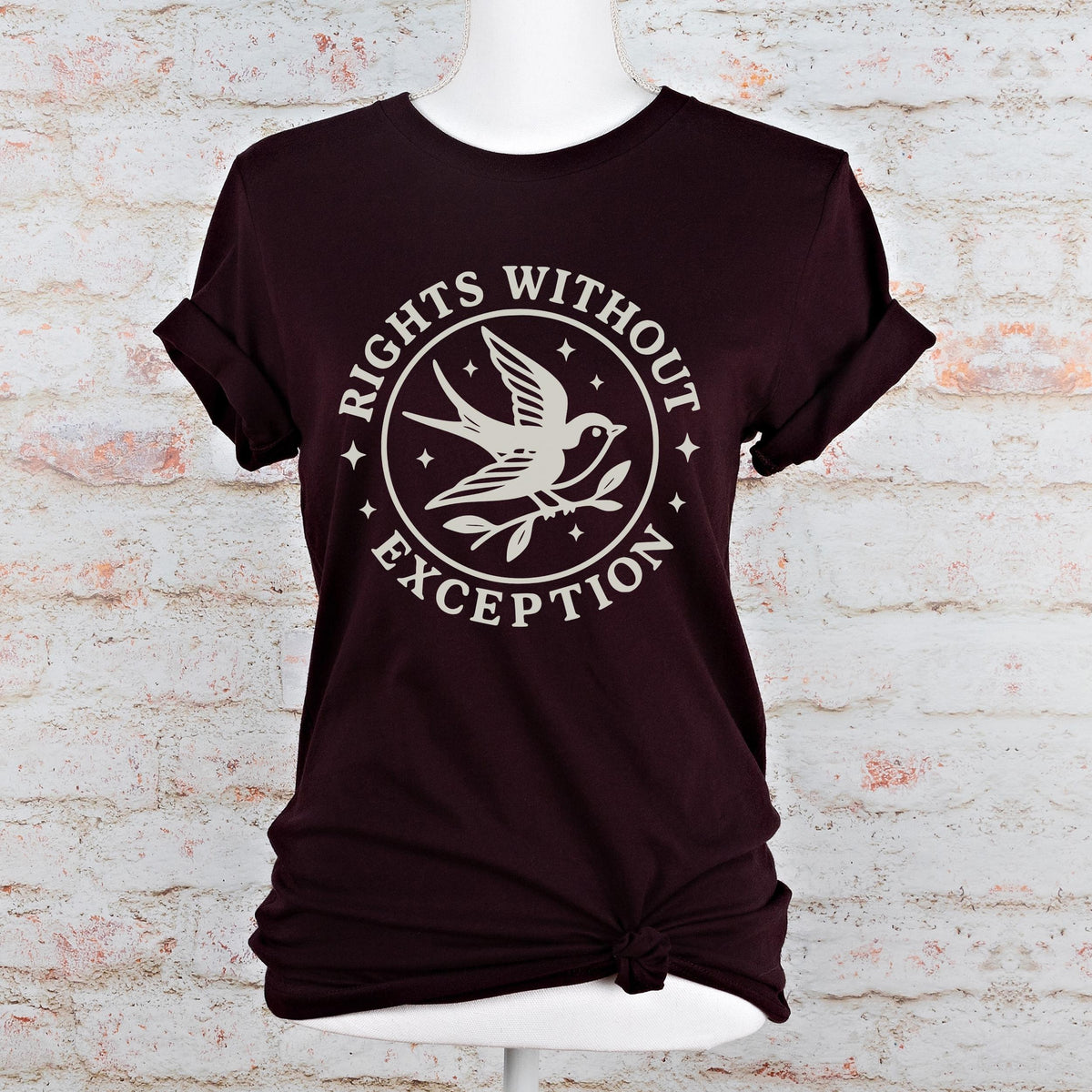 The Faithful Familiar unisex dark green graphic tee with a cream swallow and Rights Without Exception emblem print.