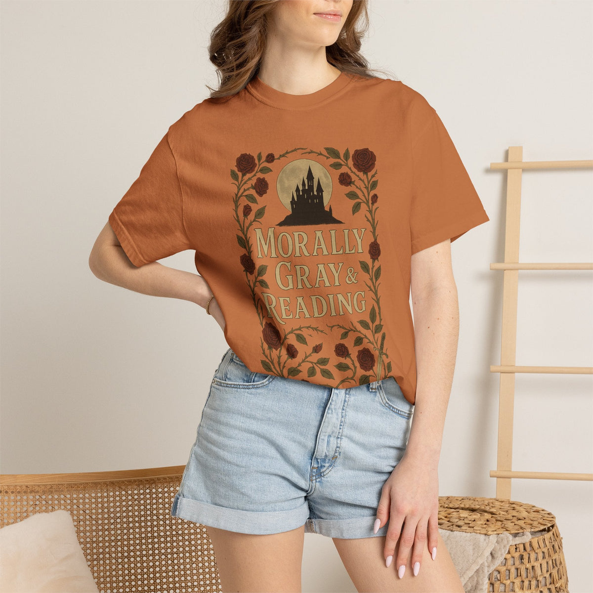 The Faithful Familiar garment-dyed cotton t-shirt in burnt orange featuring a gothic castle and floral bookish graphic.