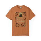 The Faithful Familiar garment-dyed cotton t-shirt in earthy orange featuring a gothic castle and floral bookish graphic