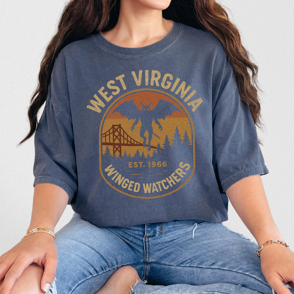 The Faithful Familiar vintage-style Mothman graphic t-shirt in washed navy with a retro mustard and orange badge design.