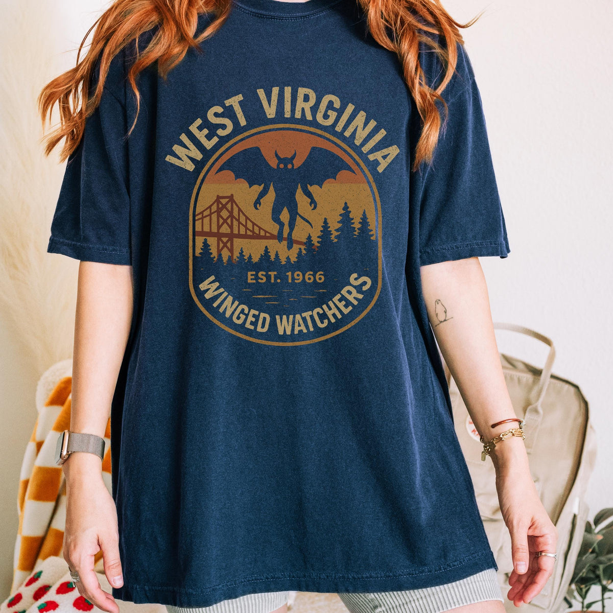 The Faithful Familiar navy blue Comfort Colors t-shirt with a vintage Mothman graphic and West Virginia badge design.
