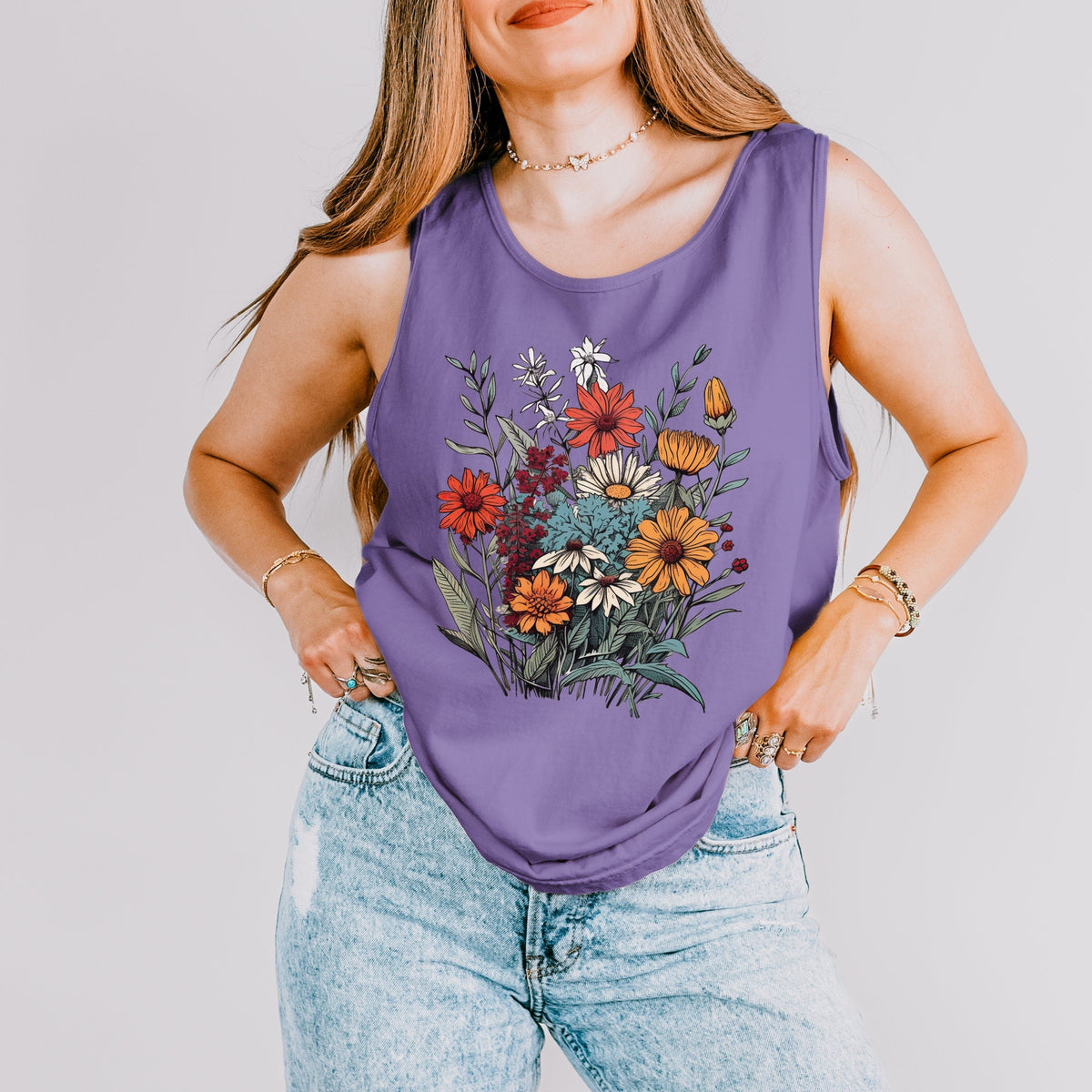 The Faithful Familiar purple slouchy boho tank top with a vintage wildflower graphic, worn with light wash jeans.